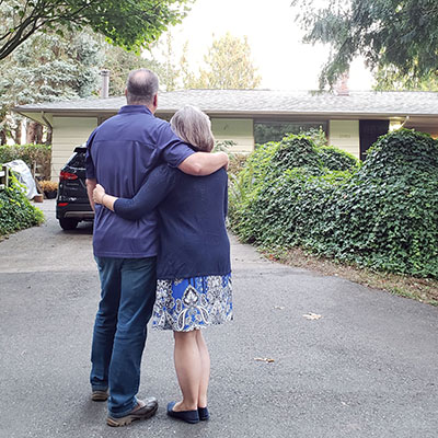 Happy home owners enjoying their new roof that started with a free roofing estimate.