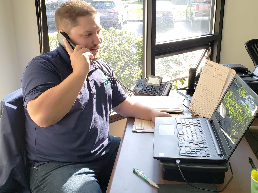 Neil from Three Tree Roofing taking a phone call from a new roof customer