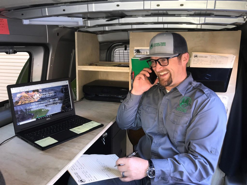 CJ McConaghy, Co-Owner & Co-Founder, Three Tree Roofing - on a call with a home owner new roof client