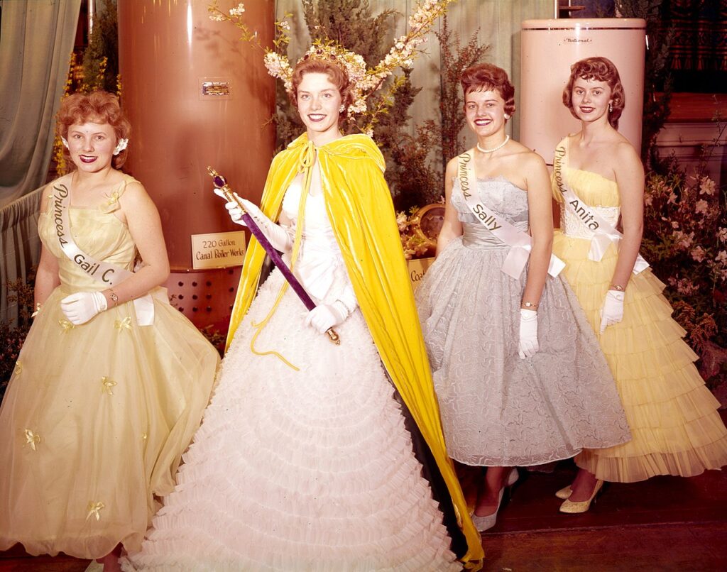 1959 Puyallup Daffodil Queen Carol Mills and her court, posing with (yes, really) water boilers. Left to right: Gail Cristensen of Puyallup, Carol Mills of Franklin Pierce, Sally Yoder [Crowe] of Sumner, Anita Lamp of Tacoma.