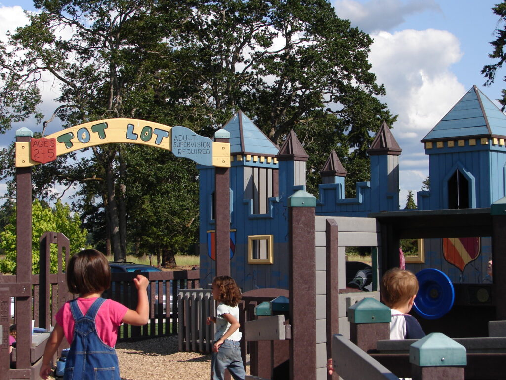 Fort Steilacoom Tot Lot playground with colorfully painted child size towers and wooden structures.