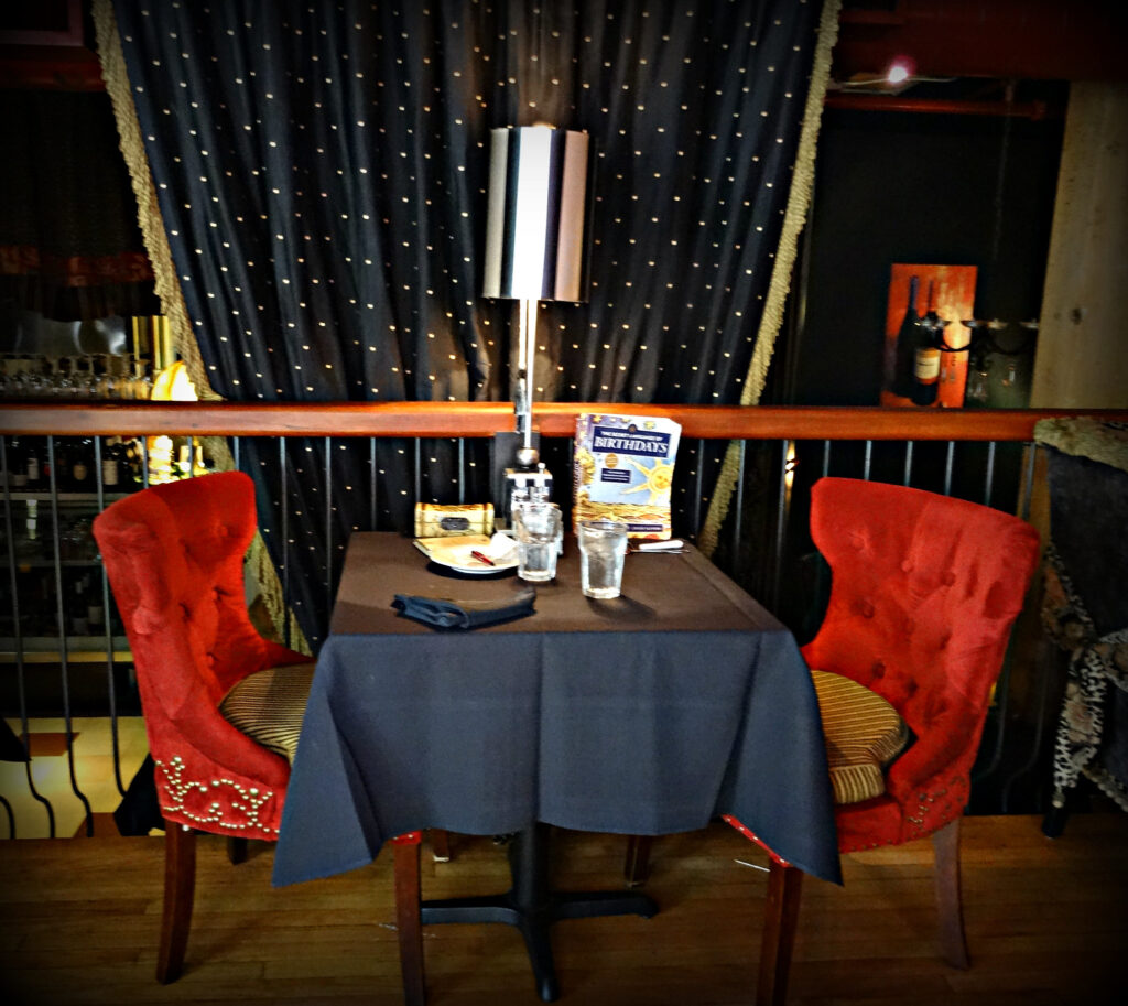 Table for two with red velvet chairs in the upper dining room at Over The Moon Cafe in Tacoma, Washington.