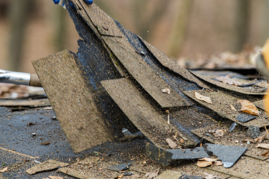 Shingles being torn off a roof during the roof tear off phase of a composite roofing project