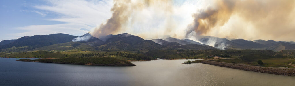 Panoramic view of a wildfire burning through Colorado mountains
