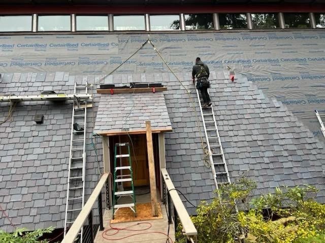 Finishing a roof replacement by adding new shingles over the underlayment.