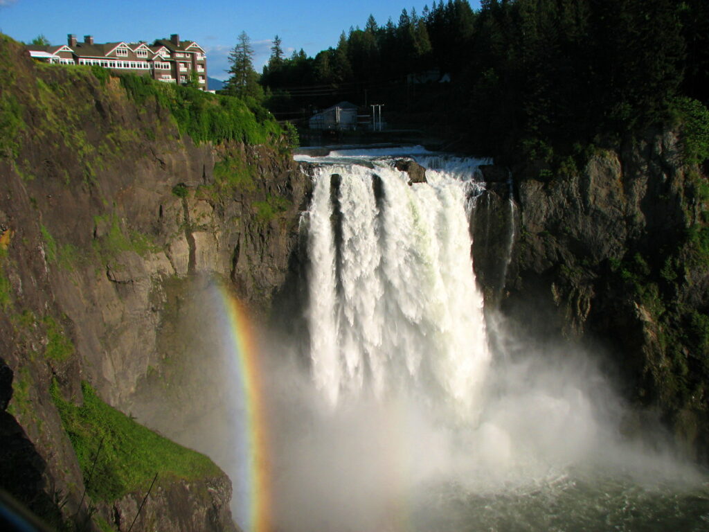 Majestic Snoqualmie Falls with a rainbow from the middle to the base of the falls, Snoqualmie, Washington