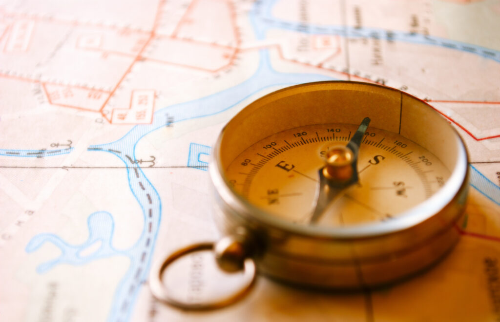 Vintage Compass for Knowing the Direction of Your Roof Lying on a Map