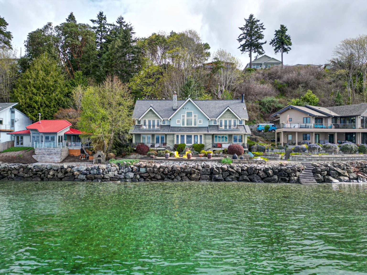 Zoomed out view of front of house with lake in front with a new Synthetic Cedar Shake Roof in Burien, Washington
