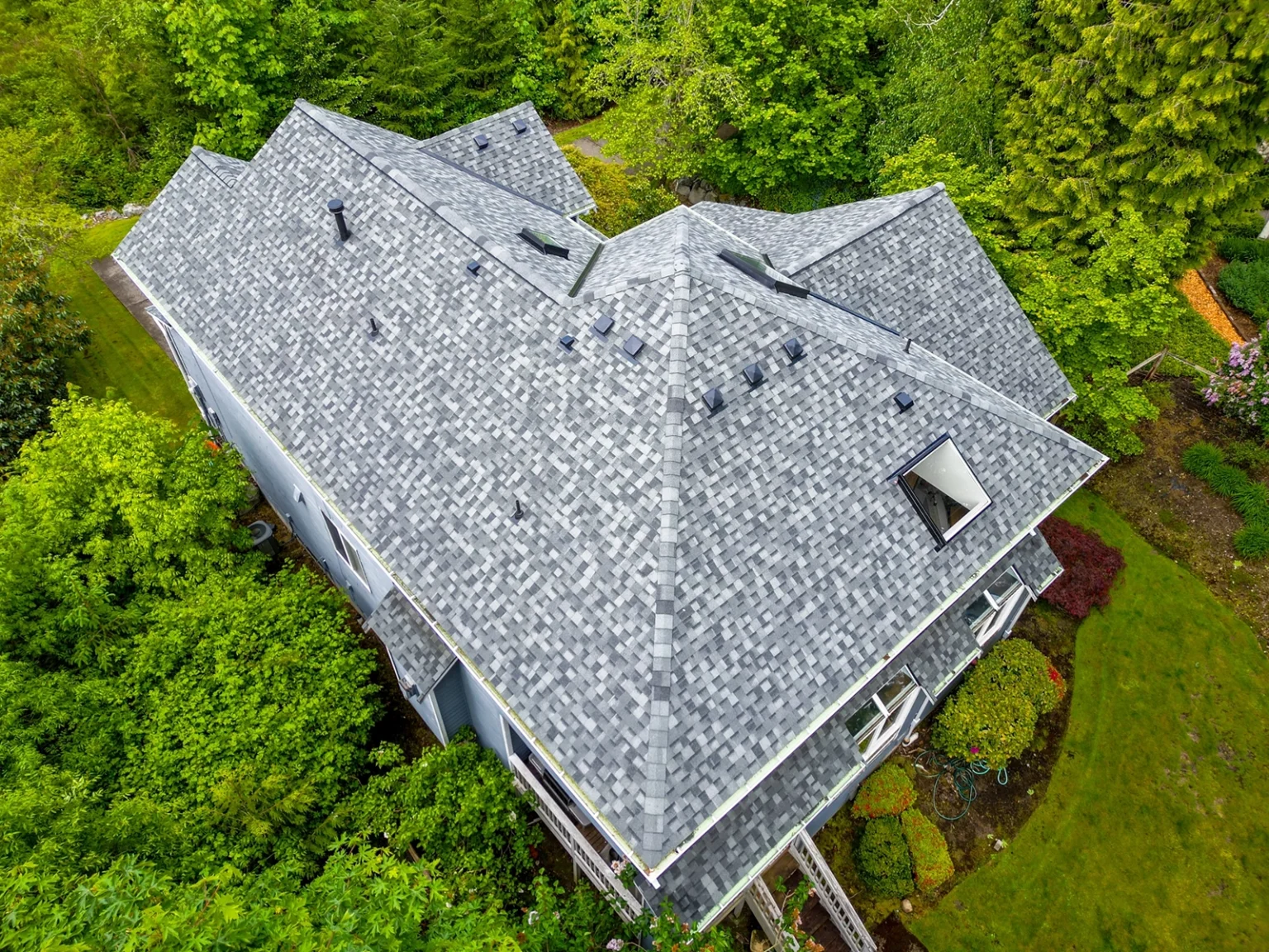 Overhead view from an angle of roof details from back of a house with a new Composite Asphalt Shingle New Roof Replacement in Bellevue, Washington