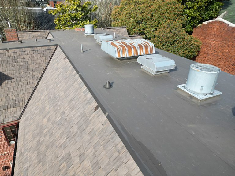 View of top roof details of a building with a Synthetic Shake Shingle Church and School Roof in Seattle, Washington
