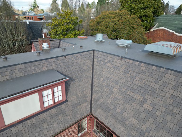 View of top roof details of a building with a Synthetic Shake Shingle Church and School Roof in Seattle, Washington
